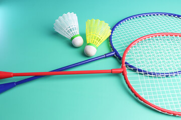 badminton rackets and shuttlecocks in a green background. 