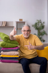 Fototapeta premium Old man with many pillows at home