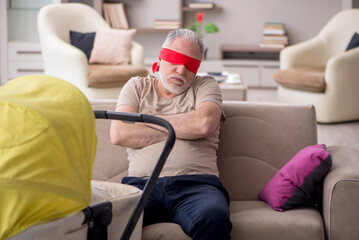 Old man looking after newborn at home