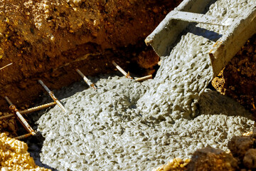 Cement ready mix concrete pouring for building foundation by construction worker