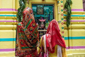 Women in very colorful clothing walking through the streets of Varanasi, India.