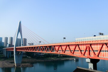 Naklejka premium a red bridge with cars going over it next to a lake