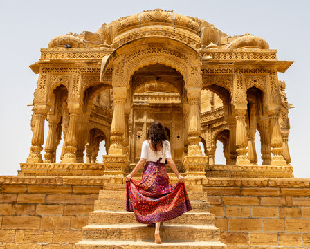 Woman at Bada Bagh with wind towers, near Jaisalmer in Rajasthan, India. The golden city of the Thar desert