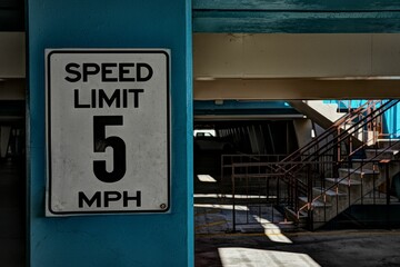 Close-up shot of a speed limit sign affixed to the column in a parting lot