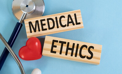 Ethics word written on wooden blocks and stethoscope on blue background. Healthcare conceptual for...