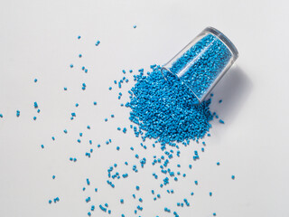 cold cut type blue pearlish masterbatch granules with glass cup in white background photo. This material is a coloring agent for products of the plastics industry