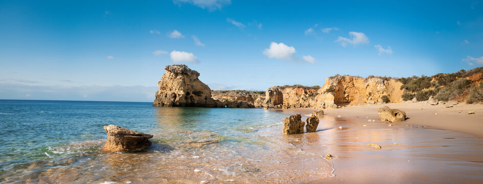 Golden beaches and sandstone cliffs near Albufeira, Portugal Panoramic banner image.