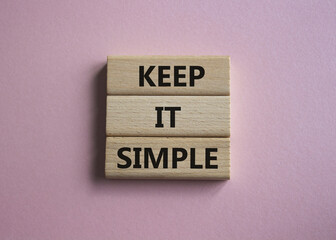Keep it Simple symbol. Concept words Keep it Simple on wooden blocks. Beautiful pink background. Business and Keep it Simple concept. Copy space.