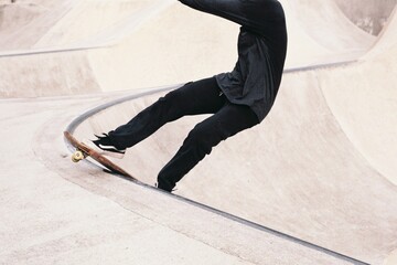 Young adult male is seen skateboarding in a skatepark