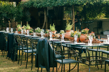 Outdoor dining setup for a sophisticated event featuring crystal glassware, polished plates, and a...