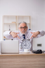 Old male employee in time management concept