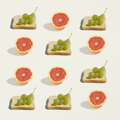 A slice of bread with grapes and a sliced grapefruit on a beige background. Concept of healthy...