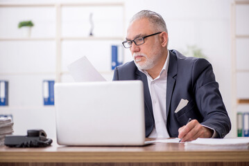 Old male employee working in the office