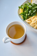 Fresh delicious breakfast with tea, crispy toaster with cheese, omelet and fresh salad on a light background. The concept of proper nutrition. Copy space