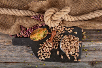 Pistachios briefly in copper bowl on wooden rustic background, wonderful pistachio composition for healthy and dietary nutrition. Pistachio concept.