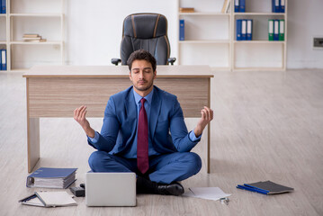 Young male employee unhappy with excessive work in the office