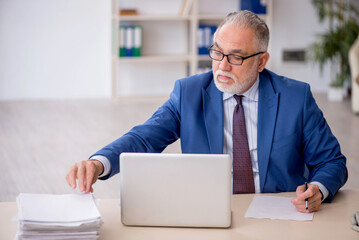 Old male employee working in the office