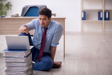 Young male employee unhappy with excessive work in the office