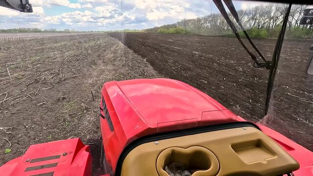 View from the cab of an agricultural tractor on the field.