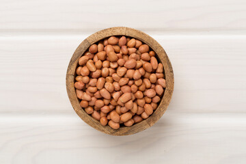 Peeled peanuts on wooden background, top view
