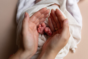 little feet of a newborn baby in mother's hands