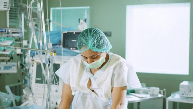 An African-American female patient sits on a hospital bed and waits for surgery. Preparation for surgery in the surgical room. Endoscopy, caesarean section. Preparing the final stages before surgery