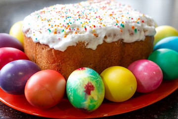 festive Easter cake, decorated with white fondant, painted multi-colored eggs lie around