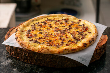 Brazilian pizza, bacon pizza with cheese, tomato sauce, cheese, rustic wooden background