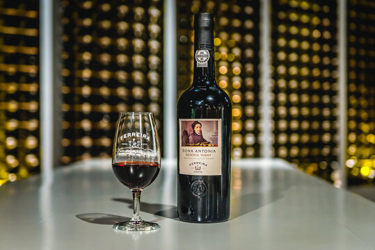 Vila Nova de Gaia, Portugal - November 13, 2017: Glass and bottle of Ferreira Dona Antonia Reserva Tawny Port in Ferreira wine Cellars in Vila Nova de Gaia