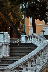 Vertical shot of a staircase in front of a building with many trees
