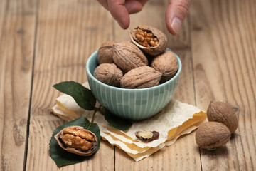 Wooden background with walnuts and hands.