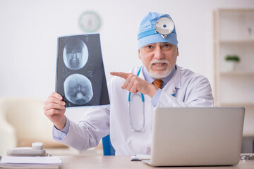 Old male doctor otologist working in the clinic