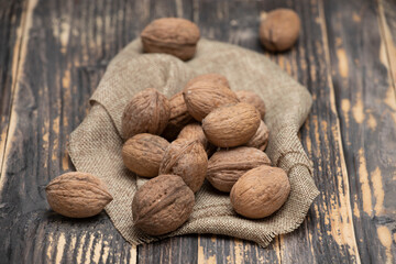 Whole walnuts on a wooden background, top view