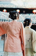 Women wearing traditional Chinese oriental clothing walking down a historic street