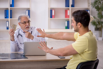 Young male patient visiting old male doctor