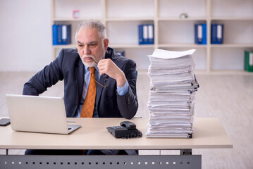 Old male employee unhappy with excessive work in the office