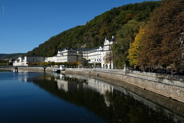Fototapeta na wymiar Tranquil lake with buildings and green hills on the shore. Bad Ems, Rhineland-Palatinate, Germany.