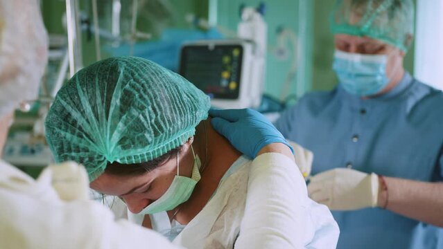 Spinal anesthesia injection, epidural anesthesia or nerve block. Anesthesiologist at work. Doctor inserts a needle into the patient's spine for anesthesia. Pain relief in preparation for surgery