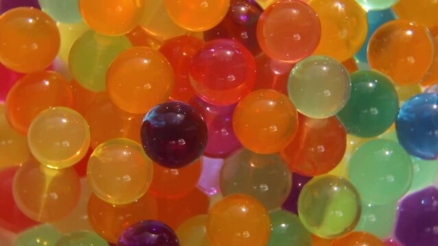 Colorful Orbeez balls are spinning. ASMR video. Colorful balls rotate and shine.