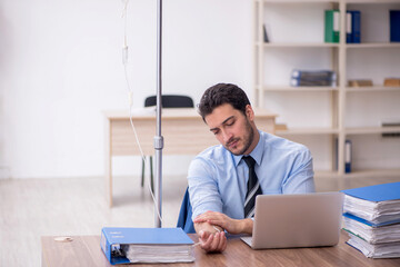 Young male employee suffering at workplace