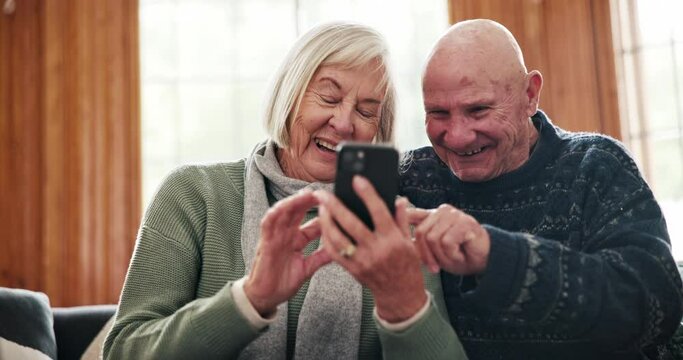 Phone, comic and senior couple on sofa laughing at meme, joke or gif message in their home together. Funny, love and old people with smartphone, app or joke in a living room having fun in retirement