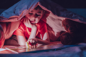 Curious little boy plays an interesting game with a toy instead of sleeping at night