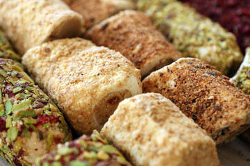 Rolls of turkish delight with many different flavors and fillings close up on table of vendors market bazaar