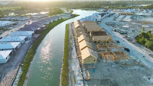 Aerial view of unfinished wooden frames of affordable houses under construction. Development of residential housing in American suburbs. Real estate market in the USA