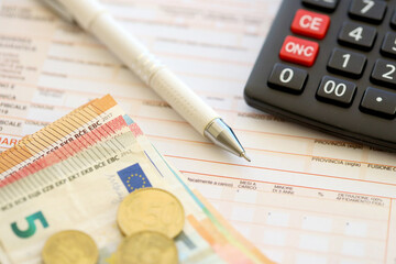 Filling italian tax form process with pen, calculator and euro money bills close up. Tax paying period and deadline