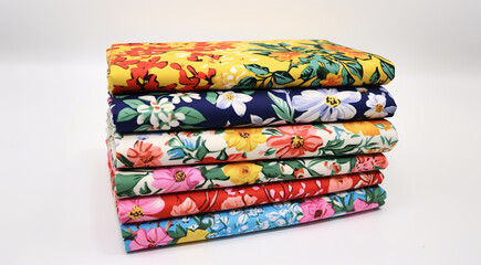 Fototapeta na wymiar a stack of floral print cloth material sections