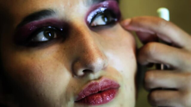 young woman holding mascara apply on eyeleashes prepare getting ready in the morning, smiling beautiful girl doing make up put cosmetics and lipstik on face looking in mirror in dressing room