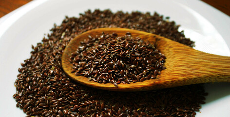 Closeup of a spoonful of flaxseed under hard light.