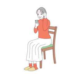 椅子に腰掛けスマートフォンを操作する上品なシニア女性