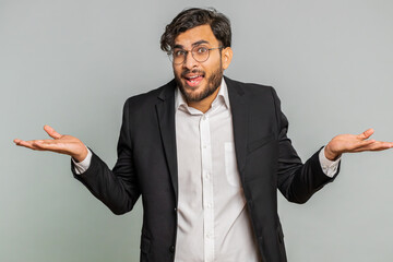 What. Why. Angry Indian businessman raising hands in indignant expression, asking reason of failure demonstrating disbelief irritation by troubles. Arabian young man isolated on gray studio background
